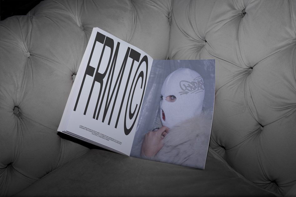 Open magazine mockup on a tufted couch showing bold typography and fashion photography, ideal for editorial design presentations.